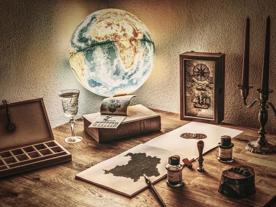 团队编辑在复古木质书桌前用多台设备同步记录人体反应速度测试器成绩并比对屏幕刷新率差异